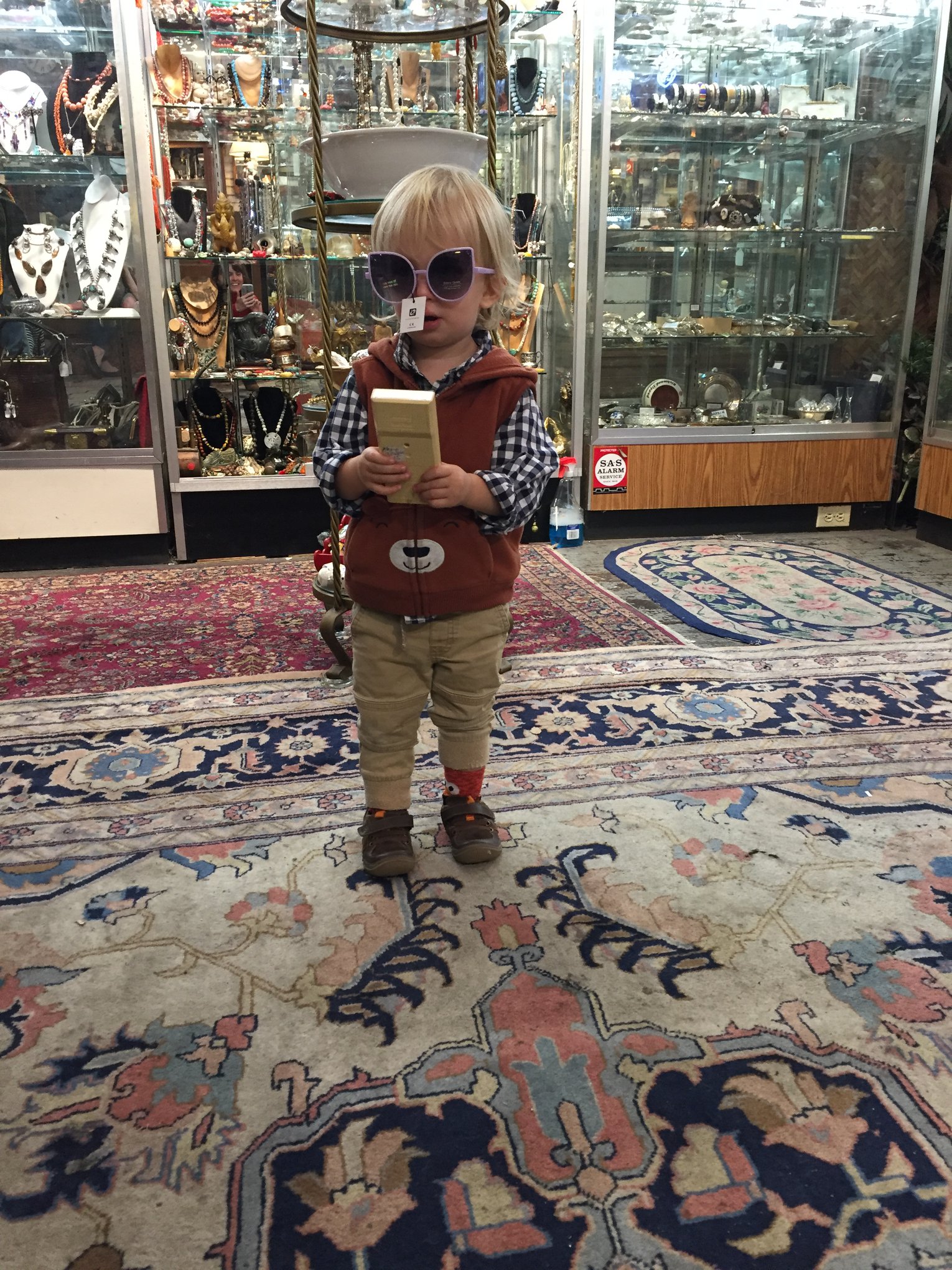 Young child wearing sunglasses and holding item found in store